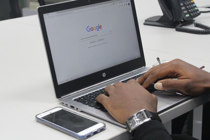Eine Person nutzt die Google-Suche auf einem Laptop.