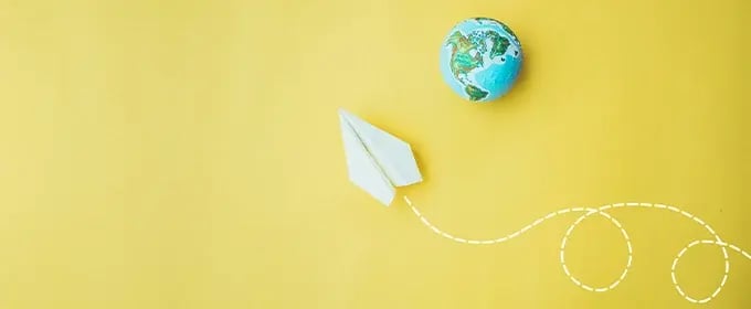 Grafik: Ein Papierflieger fliegt um eine Weldkugel.