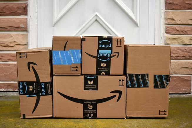 Vor einer Haustür stehen mehrere Pakete von Amazon Prime.