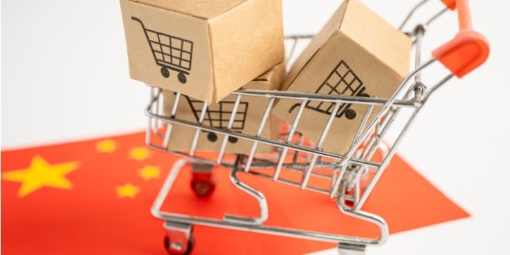 Ein Einkaufswagen mit Paketen auf einer chinesischen Flagge