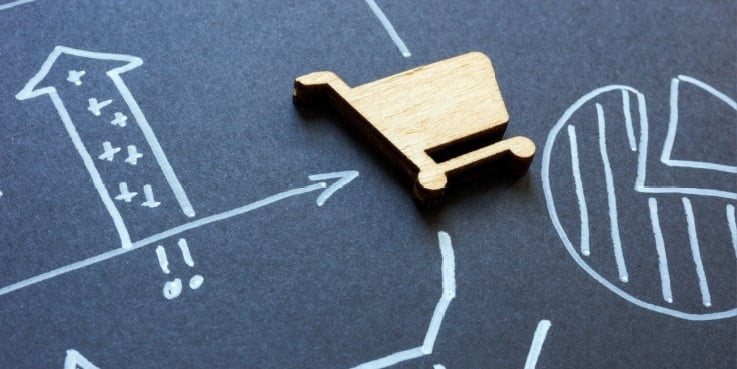 Ein Einkaufswagen liegt auf einem Board mit Pfeilen und Berechnungen.