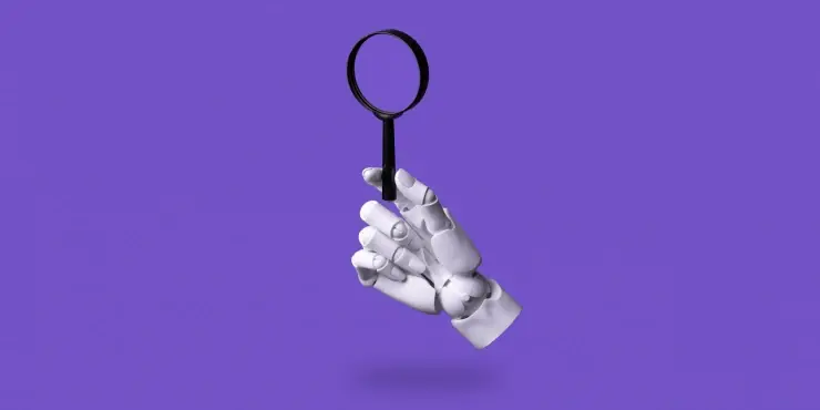 Eine Roboterhand hält eine Lupe in die Höhe.